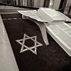 Zwoje Tory, otwarta księga i Gwiazda Dawida na aksamicie. Symbolika żydowskiego pogrzebu.