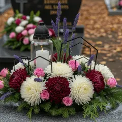 Kompozycje z żywych kwiatów na Wszystkich Świętych: bukiet z białych i bordowych chryzantem, róż, lawendy i świecy.