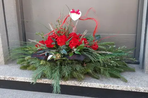 Wiązanki z róż na Wszystkich Świętych, ozdobione sercem i gałązkami iglaków, tworzą elegancką kompozycję.
