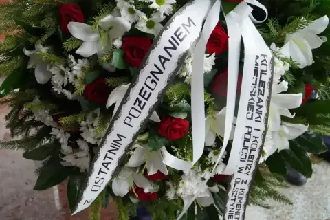 Oryginalny napis na szarfie pogrzebowej: "Z ostatnim pożegnaniem Koleżanki i Koledzy z Komendy Miejskiej Policji w Olsztynie".