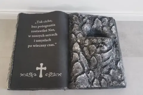 Stroik książka na cmentarz z cytatem i krzyżem. Prawa strona imituje kamieniste zbocze.