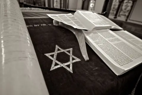 Zwoje Tory, otwarta księga i Gwiazda Dawida na aksamicie. Symbolika żydowskiego pogrzebu.