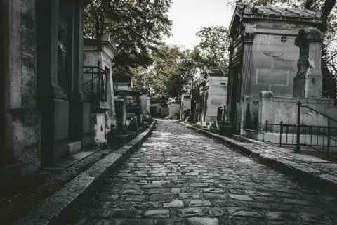 Kamienna ścieżka prowadzi przez cmentarz, otoczony mauzoleami. Zastanawiasz się, jak często chodzić na cmentarz?