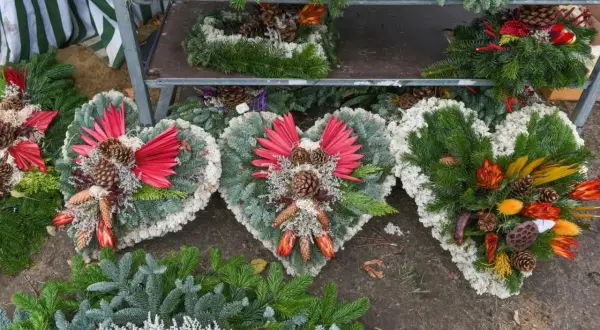 Ekskluzywne sztuczne kwiaty na cmentarz w kształcie serc, ozdobione szyszkami i suszonymi roślinami, tworzą elegancką kompozycję.
