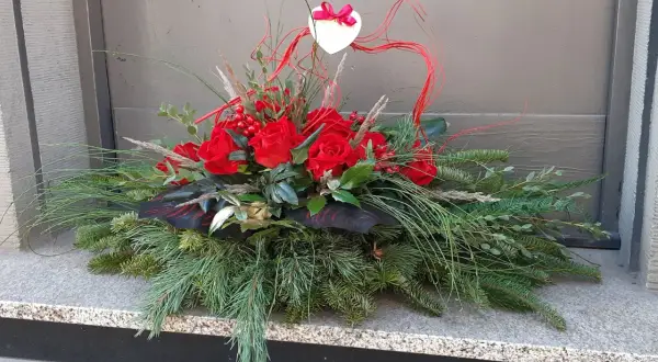 Wiązanki z róż na Wszystkich Świętych, ozdobione sercem i gałązkami iglaków, tworzą elegancką kompozycję.