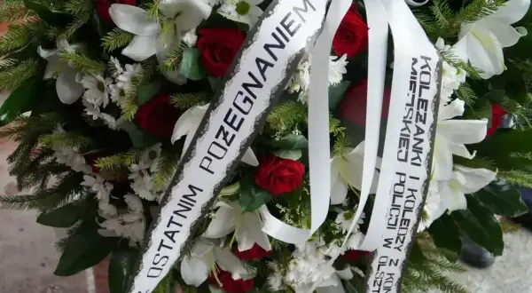 Oryginalny napis na szarfie pogrzebowej: "Z ostatnim pożegnaniem Koleżanki i Koledzy z Komendy Miejskiej Policji w Olsztynie".