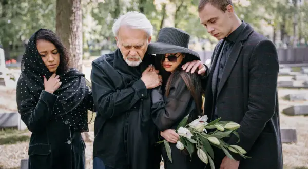 Smutna rodzina na cmentarzu. Na mój pogrzeb obowiązuje dress code: czerń i żałobne nakrycie głowy.