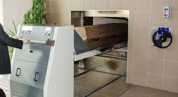 Wózek z trumną wjeżdża do pieca kremacyjnego. Proces ten nie powoduje bólu, jest to ostatnie pożegnanie.