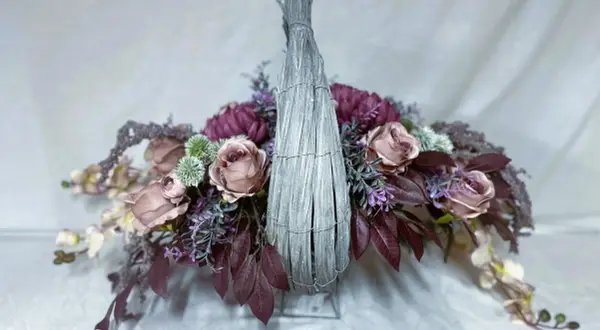 Eleganckie kompozycje ze sztucznych kwiatów w koszu, z różowymi różami, fioletowymi akcentami i zielonymi detalami.