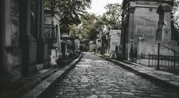Kamienna ścieżka prowadzi przez cmentarz, otoczony mauzoleami. Zastanawiasz się, jak często chodzić na cmentarz?