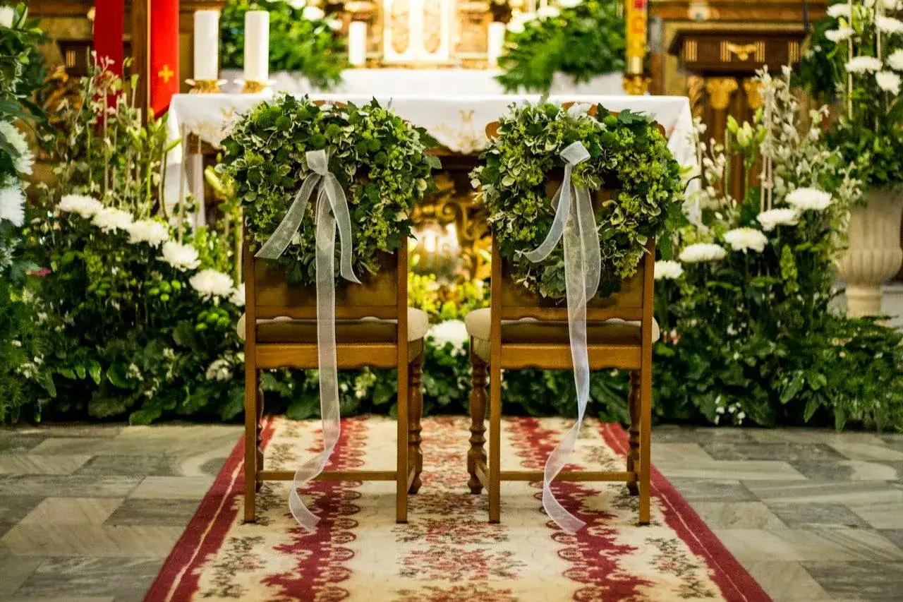 Dwa ozdobione wieńcami krzesła w kościele, przygotowane na uroczystość zielonoświątkowcy pochówek.