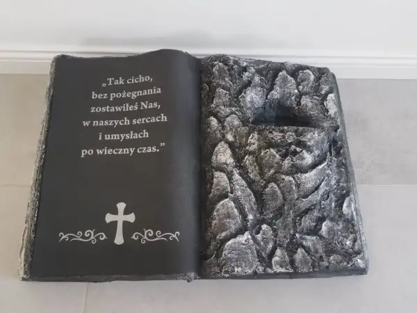 Stroik książka na cmentarz z cytatem i krzyżem. Prawa strona imituje kamieniste zbocze.
