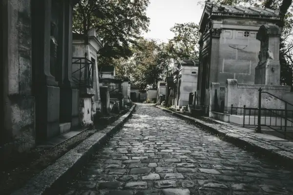 Kamienna ścieżka prowadzi przez cmentarz, otoczony mauzoleami. Zastanawiasz się, jak często chodzić na cmentarz?